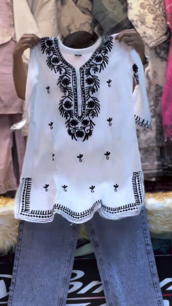 Elegant White Embroidered Kurta with Intricate Black Floral Detailing and Matching Light Blue Jeans for a Stylish Ethnic-Casual Look